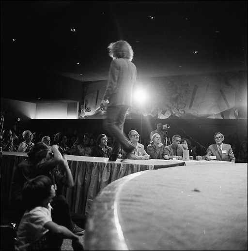 Masquerade - Roger Freedman as M.C. (standing); seated in front, from Roger's right, Forrest Ackerman, Roy Thomas, Jack Kirby, Bjo Trimble (behind Kirby), and Kirk Alyn; on the left, the white-haired woman looking up at Roger is Forrest's wife, Wendayne Ackerman. Walter Koenig is directly below the MC.